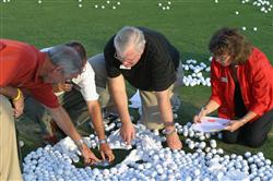 Judges carefully moving balls to find the winners.